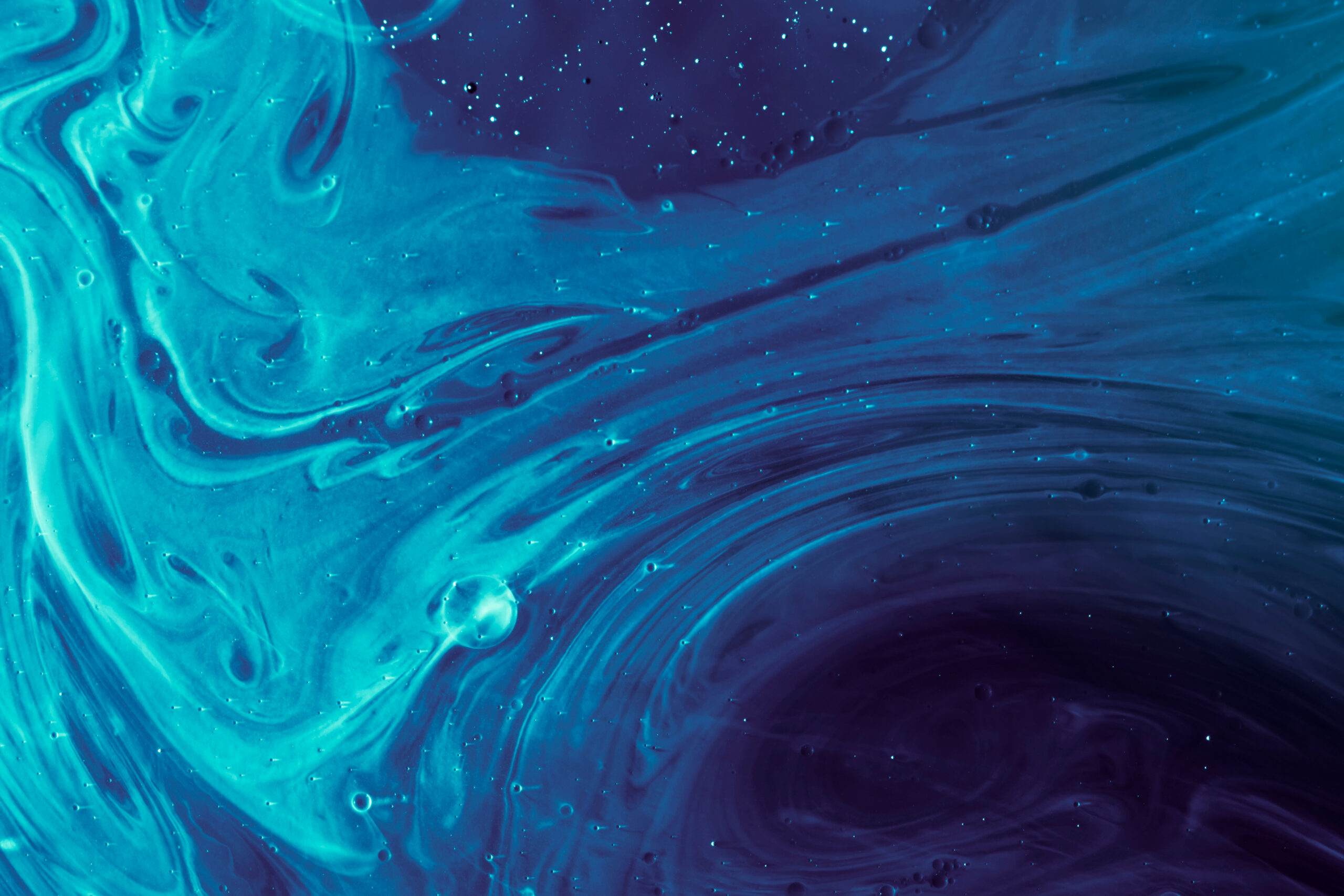 Swirling blue and turquoise liquid with light specks, creating an abstract, cosmic-like pattern.