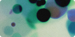 Blurry green and black spots of varying sizes on a light background, creating an abstract, out-of-focus effect.